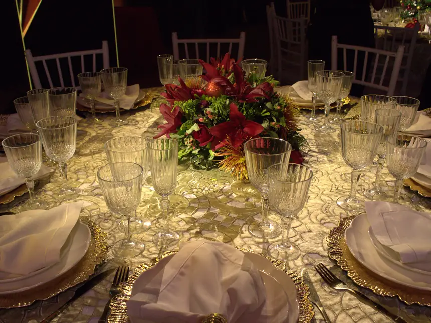Mesa posta da Festa Celebrar, com taças de cristal e pratos dourados
